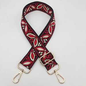 Close-up of vintage floral weave bag strap with gold metal lobster clasps and buckles