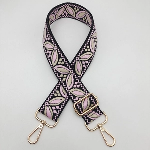 Detailed view of adjustable guitar-style pink floral woven strap with gold metal buckles