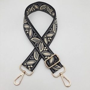 Close-up of ethnic embroidered guitar strap for bags with adjustable gold metal hardware