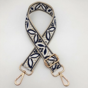 Detail of adjustable wide guitar style shoulder strap with navy leaf jacquard weave