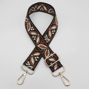 Detail of adjustable guitar style bag strap with leaf pattern and gold metal hooks