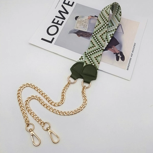 Detail of green and beige woven purse strap with gold chain and leather connectors