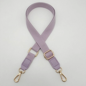 Detail view of purple cotton webbing strap with adjustable gold slider and lobster clips