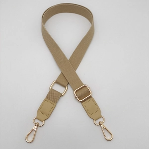 Detail of adjustable khaki cotton canvas strap with gold swivel hooks and leather ends