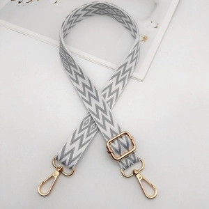 Close-up of adjustable embroidered shoulder strap with gold metal swivel lobster clasps