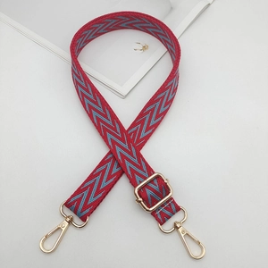 Dettaglio della tracolla intrecciata rossa e blu con moschettoni e cursore in metallo dorato