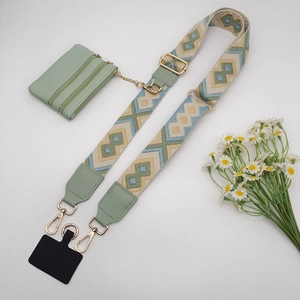 Detail view of woven bohemian shoulder strap with green leather pouch and gold hardware