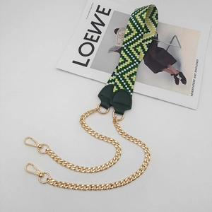 Detailed view of woven green and yellow bag strap with gold chain and lobster clasps