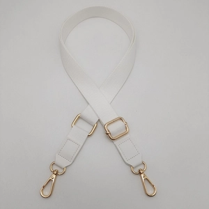 Detailed close-up of 2.5cm white cotton webbing strap with golden metal buckle and leather ends