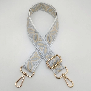 Detailed view of the blue and gold leaf pattern embroidery on this wide guitar bag strap