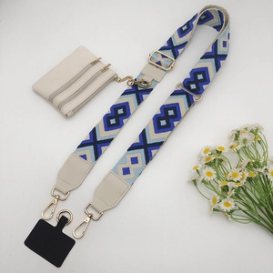 Detailed view of bohemian woven crossbody strap with white mini pouch and gold hardware