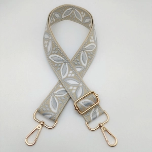 Detail of adjustable wide guitar style shoulder strap with gold metal lobster clasps