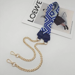 Detail of blue and white woven strap with golden metal chain and leather reinforcement