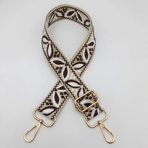 Adjustable guitar-style bag strap with golden buckles and leaf pattern weave