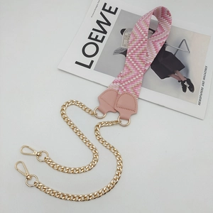 Detail of pink and white geometric webbing strap combined with a chunky gold chain