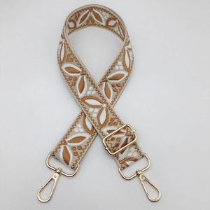 Detail of adjustable guitar-style strap with brown leaf embroidery and gold metal clips