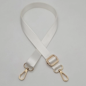 Close-up of cream adjustable woven bag strap with polished gold swivel metal hooks