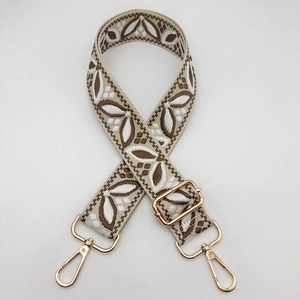 Close-up of jacquard woven geometric strap with golden lobster clasps for bags