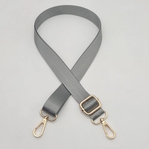 Detail of adjustable gray nylon bag strap with gold metal lobster swivel clasps