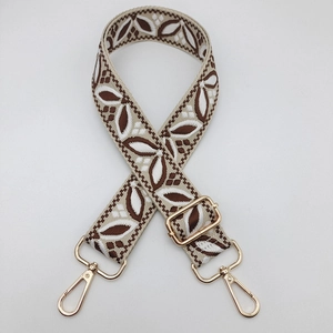 Close-up of vintage jacquard pattern shoulder strap with gold metal lobster clasps