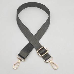 Close-up of adjustable dark gray nylon bag strap with polished gold metal hardware