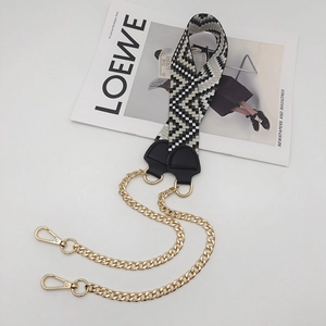 Detail of woven herringbone strap with gold metal chains and lobster clasps for handbags