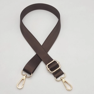 Close-up of brown herringbone woven bag strap with golden metal lobster clasps