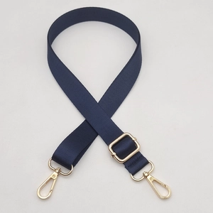 Detail of dark blue nylon strap with herringbone texture and gold swivel lobster clasp