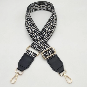 Close-up of adjustable woven shoulder strap with geometric pattern and gold hardware