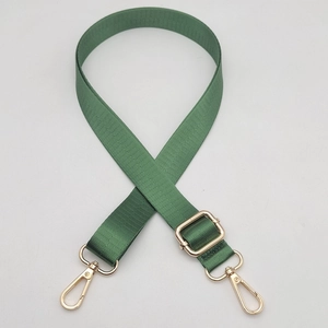 Close-up of olive green nylon bag strap with polished gold-tone metal swivel hooks