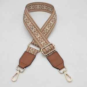 Adjustable geometric woven shoulder strap with brown leather and gold metal hooks