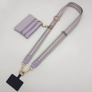 Detail of light purple phone strap with geometric pattern, gold buckles and a small wallet