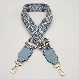 Close-up of geometric ethnic pattern woven bag strap with light blue leather ends