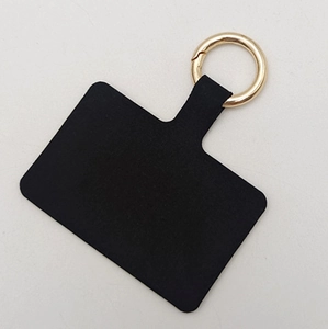 Close-up of black phone tether tab with a golden metal ring for secure crossbody strap attachment
