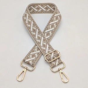 Detail of adjustable geometric jacquard strap with gold-tone hardware buckles and hooks