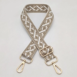 Detail view of ethnic geometric jacquard bag strap with gold metal hooks and adjuster