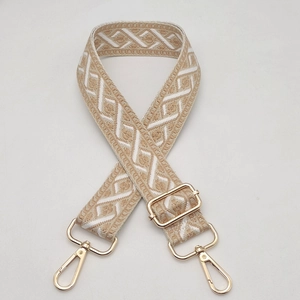 Detail of widened jacquard guitar strap with geometric pattern and gold swivel hooks