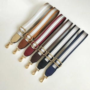 Close-up of adjustable striped canvas bag straps with gold metal hooks and leather ends