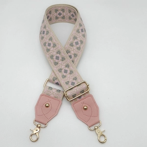 Détail de la bandoulière en jacquard géométrique rose avec ferrures dorées polies