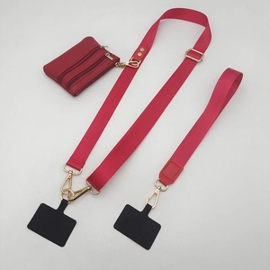 Detail van rode nylon telefoonriem set met gouden metalen clips en ritsportemonnee