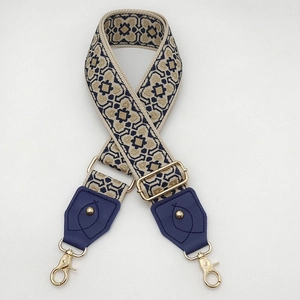 Détail de la bandoulière tissée géométrique bleu et or avec des fermoirs dorés