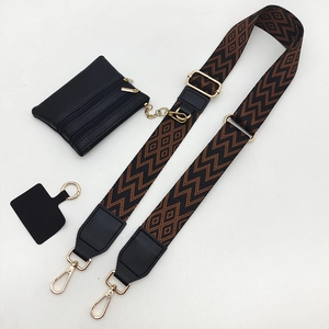 Detail view of ethnic style jacquard strap with gold hardware and leather coin pouch