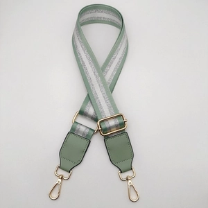 Detail of mint green adjustable strap with silver glitter stripes and gold lobster clasps