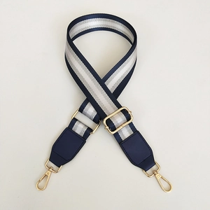Detail of adjustable blue and silver striped bag strap with gold metal swivel hooks