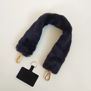 Detailed view of plush purple faux fur strap with gold hooks and phone tether tab