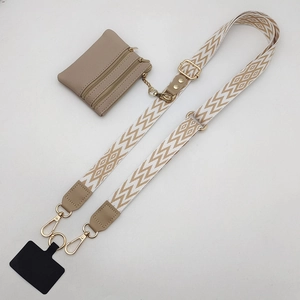 Detail view of beige geometric woven crossbody strap with khaki triple zipper pouch