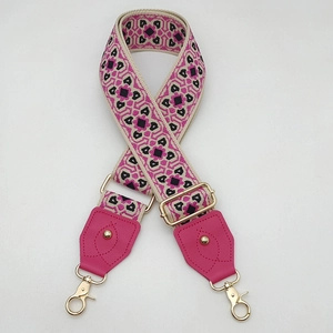 Détail de la bandoulière tissée géométrique avec cuir rose et mousquetons dorés