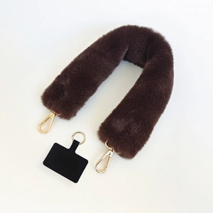 Detail of dark brown plush faux fur phone strap with golden metal lobster clasps