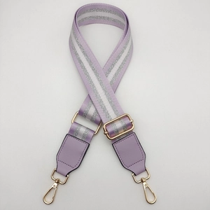 Detail of adjustable lavender nylon shoulder strap with gold hardware and stripes