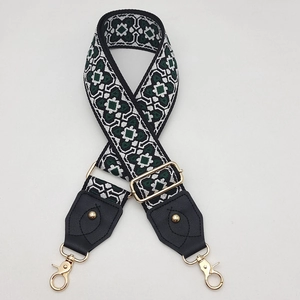 Détail de la bandoulière colorée à motif géométrique avec fermoirs mousquetons dorés